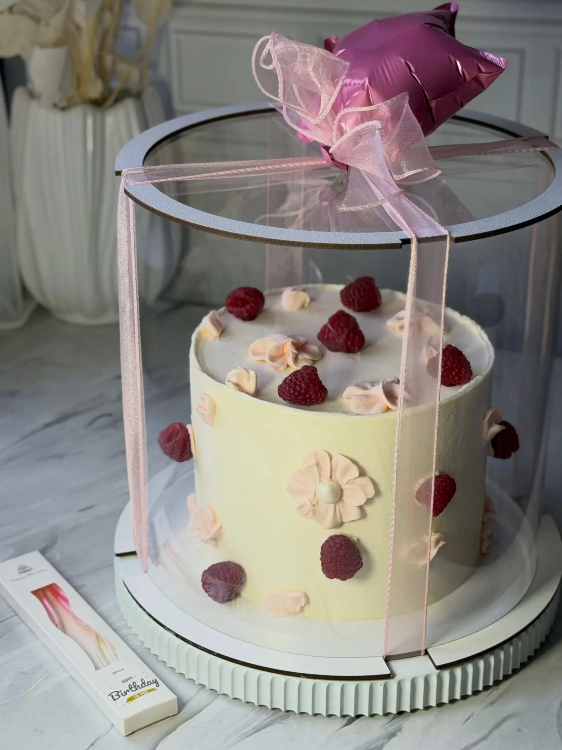 Светлый торт с малиной и цветочным декором в прозрачной подарочной коробке
